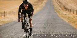 Professional athlete cycling on long countryside highway 5r9kA2