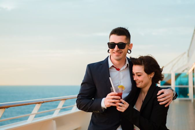 Young man and woman drinking juice from one glass