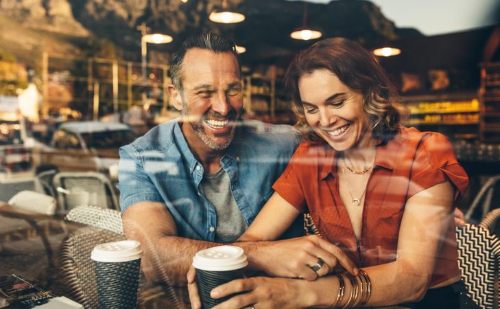 Couple sitting inside a cafe and smiling