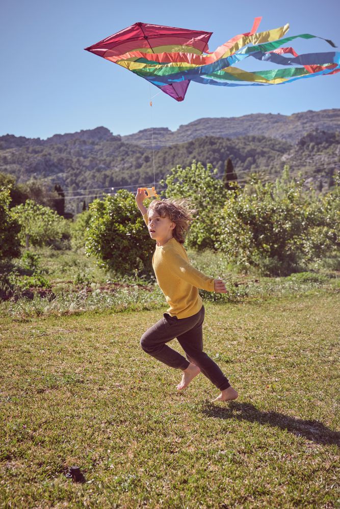 Active boy running with kite