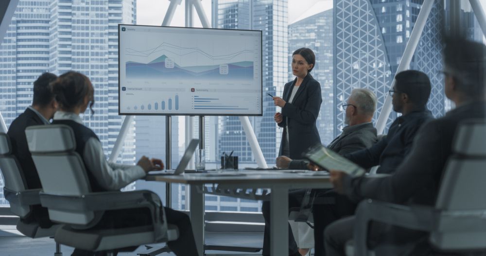 Office Conference Room Presentation: Businesswoman Talks, Uses TV Screen to Show Company Growth with Big Data Analysis, Graphs