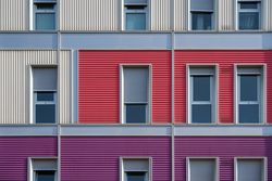 Facade of modern multicolored building with narrow windows