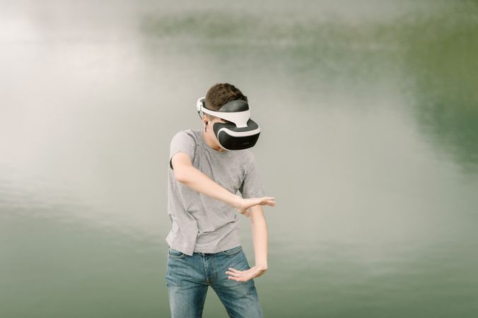 Young teenager with virtual reality glasses outdoors