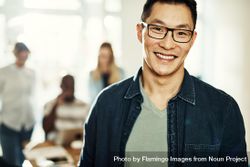 Portrait of Asian man smiling in bright office 5loMv0