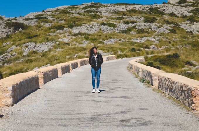 Woman standing on stony path in countryside