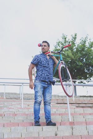 Male lifting up colorful bike on his shoulders