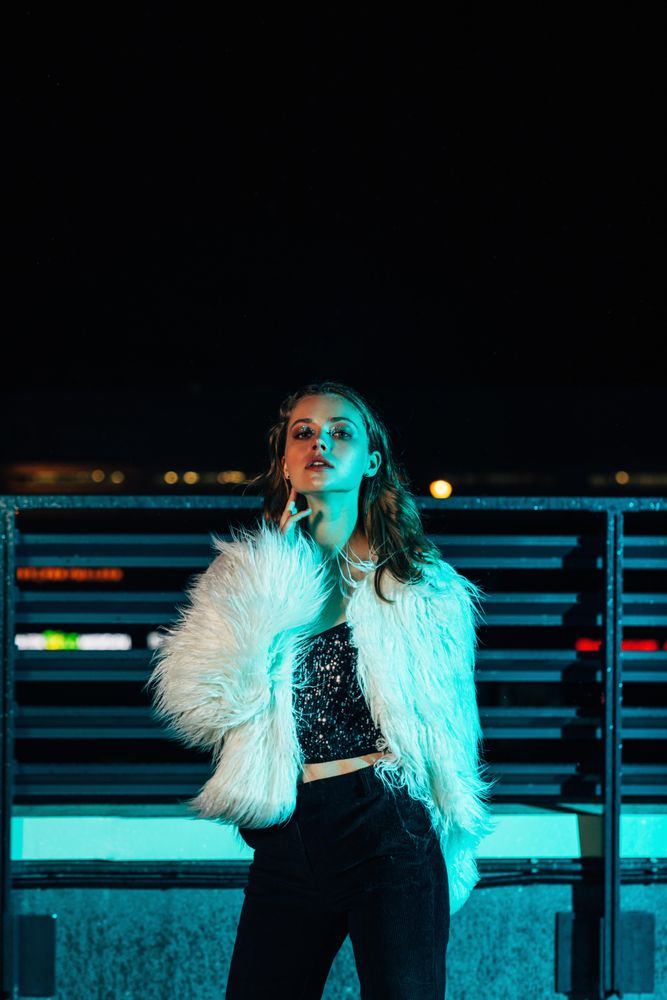 Woman posing on roof top in faux fur coat