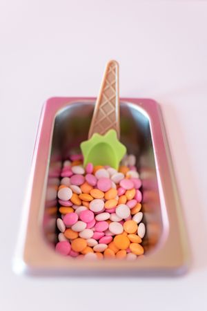 Close up photo of a metal tray filled with chocolate toppings on an ice cream parlor counter