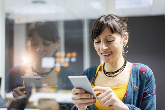 Woman browsing smartphone in office