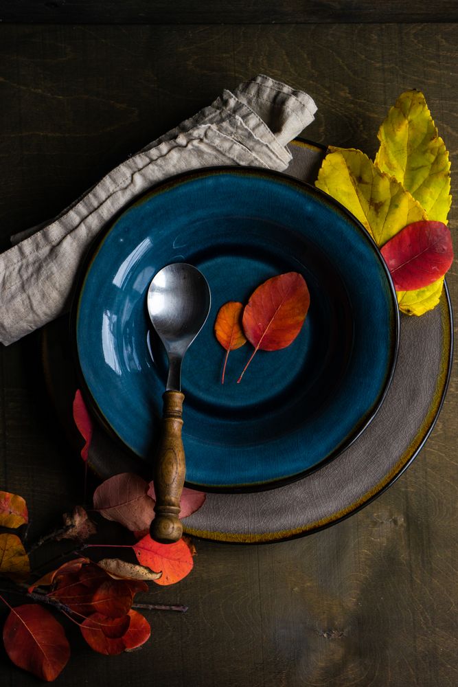 Fall place setting with colorful leaves in navy bowl