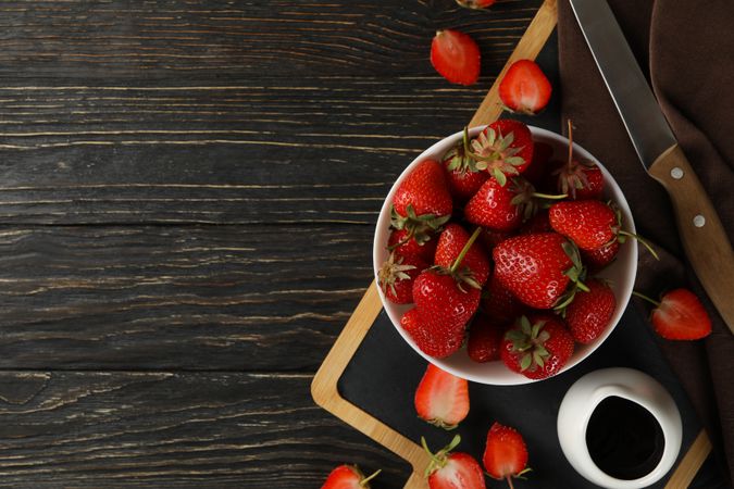 Composition with bowl of tasty strawberry on wooden table. Summer berry