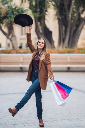 Joyful stylish woman enjoying shopping at city street