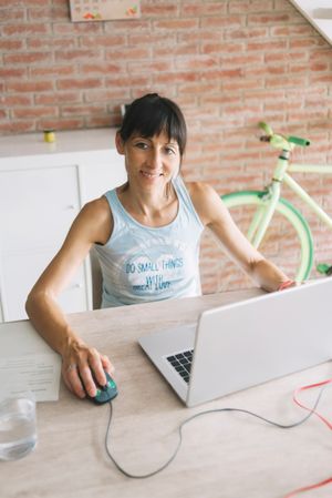 Smiling woman working at laptop at home