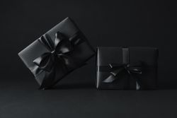 Gift boxes with dark bows on dark background