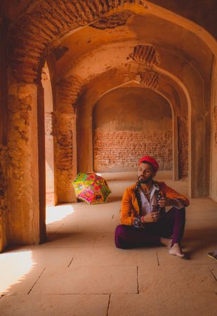 Man in traditional Indian outfit sitting in a building