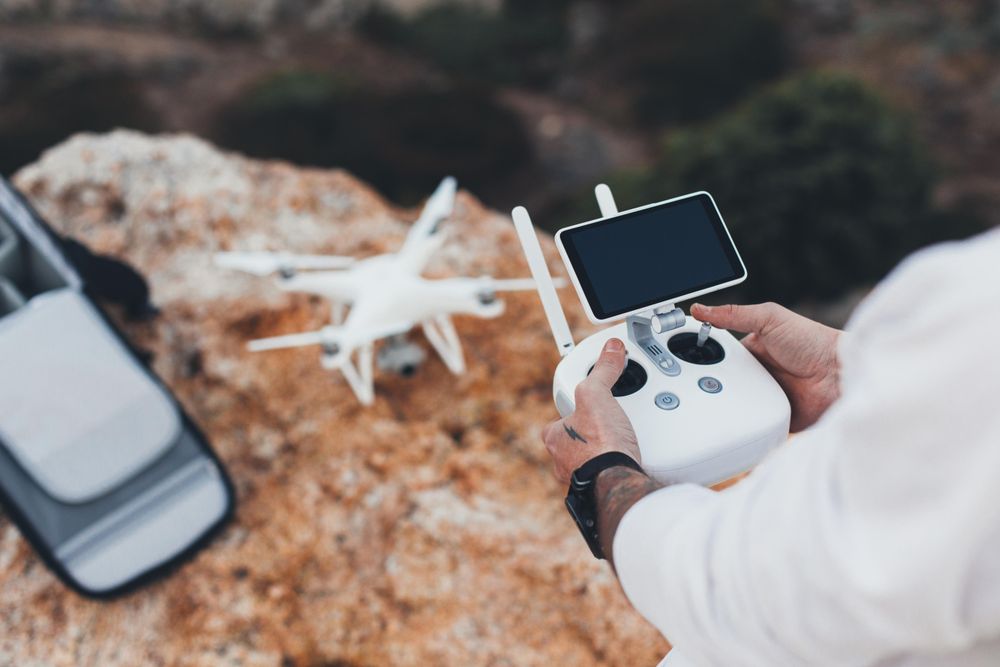 Tattooed man with remote preparing to fly drone for photography