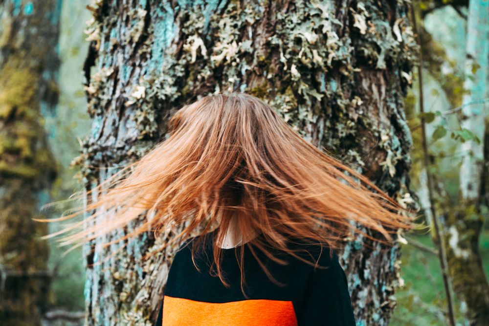 Casual redhead woman shaking with hair