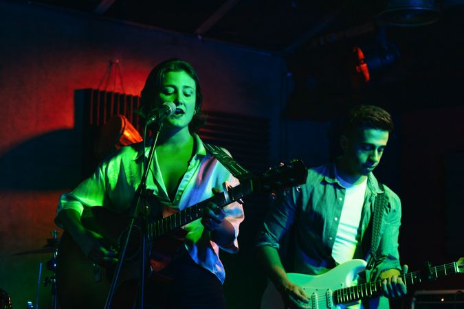 Musicians In Stage With Colorful Lights Performing In A Live Concert