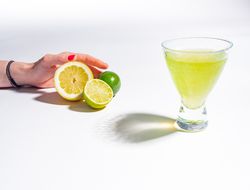 Cocktail glass with lemon juice and sliced citrus