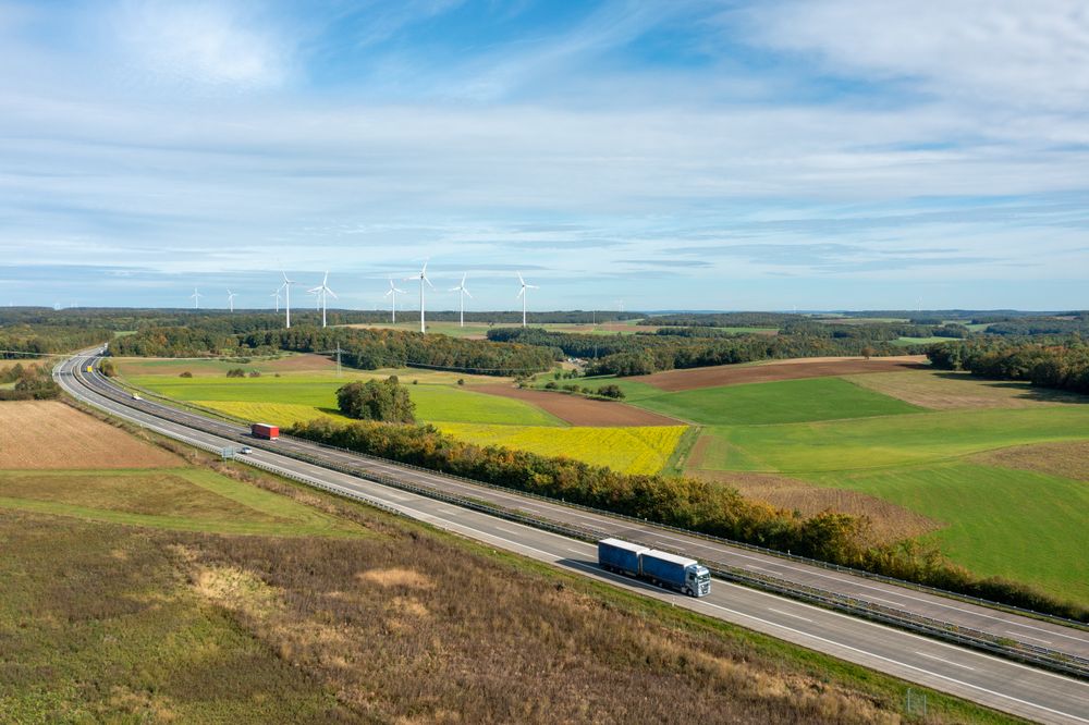 Highway and wind turbines in nature, drone aerial view in autumn