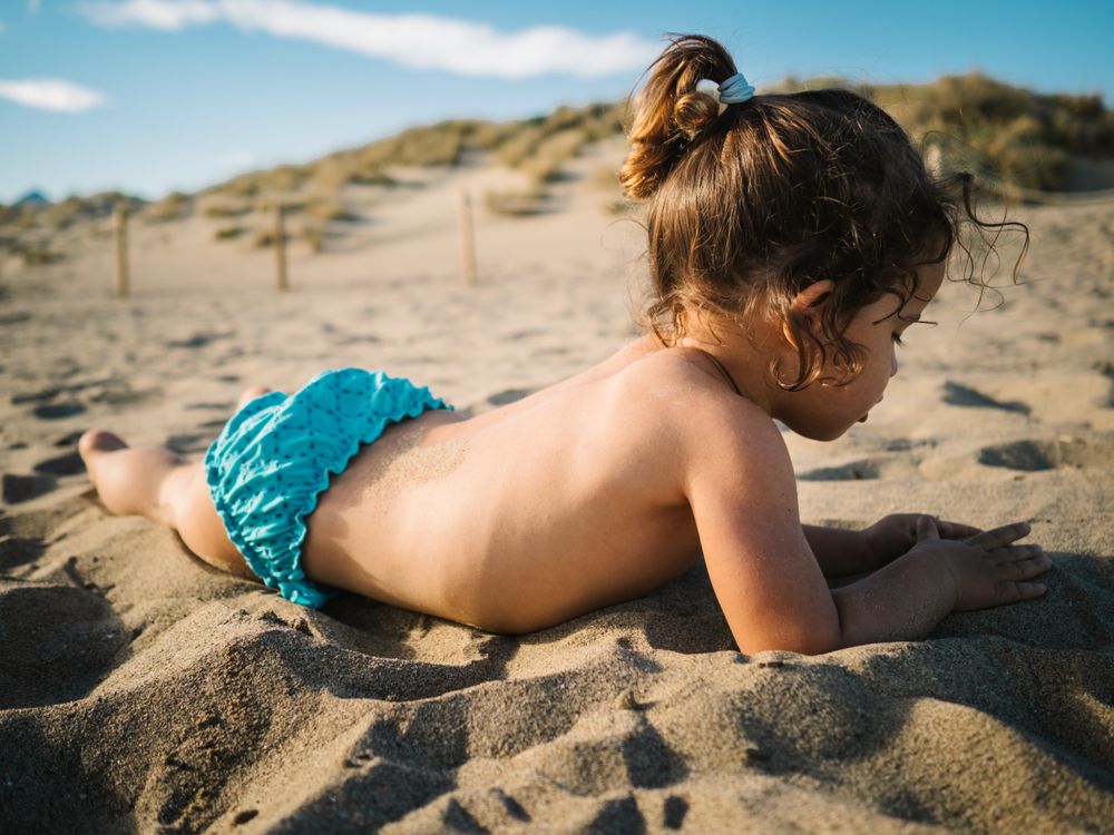 Girl playing on beach in sunny day