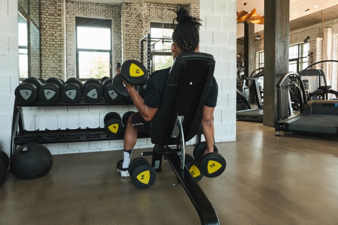 Strong man exercising with dumbbells in gym