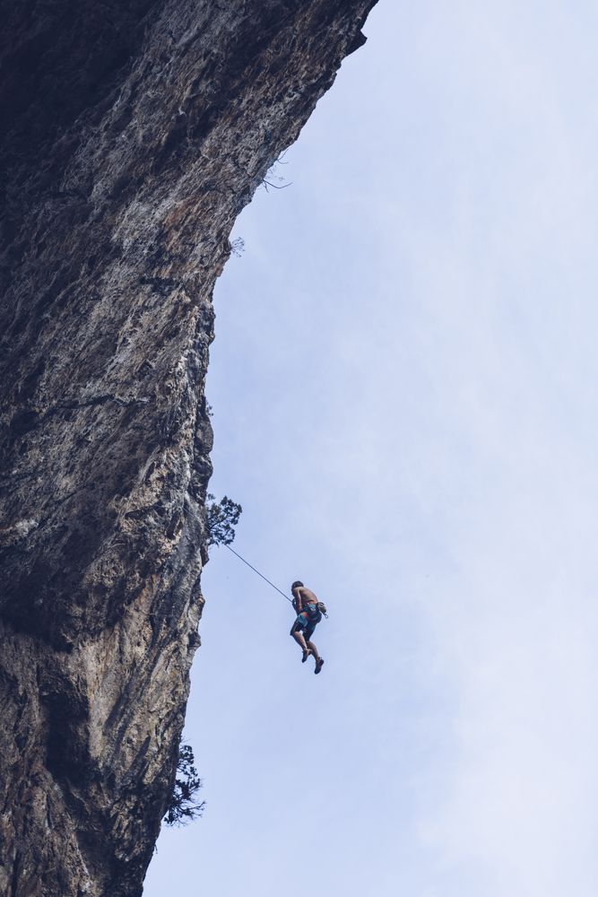 Anonymous climber handing on cliff