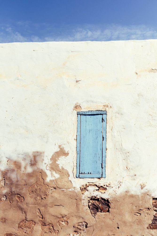 Closed window in rustic wall of old house