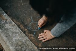Child drawing with chalk outside 4BMpP5