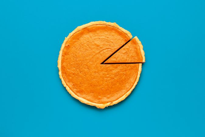Homemade pumpkin pie isolated on a blue background