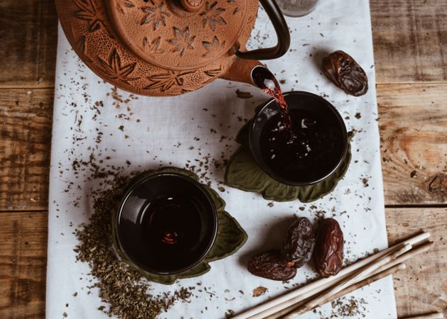 Aromatic tea dates and clay teapot on table