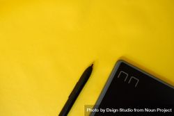 Stylus and corner of digital tablet on yellow table 5wX7rR