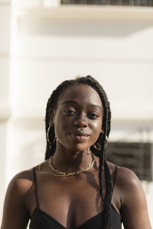 Close-up portrait of a young Black female looking to the camera in the street