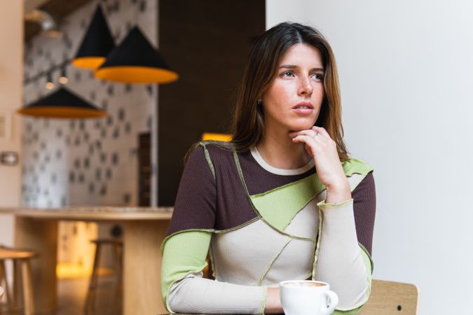 Contemplative woman with cup of coffee in cafe