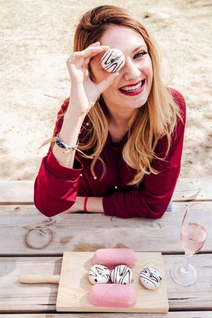 Woman looking through hole of donut