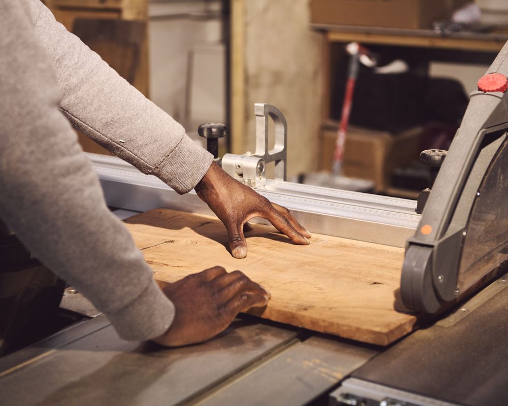 Black man cutting wood in studio