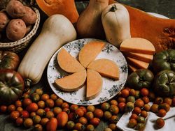 Composition of tomatoes sliced nutmeg pumpkin on plate and potatoes