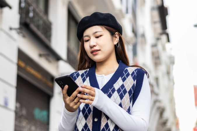 Young Asian Woman Walking and Using Smartphone in the City
