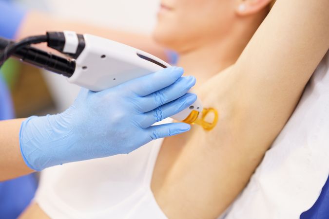 Female receiving underarm laser hair removal at a beauty center