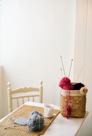 Mug of tea near knitting supplies