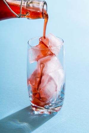 Strawberry syrup over ice cubes