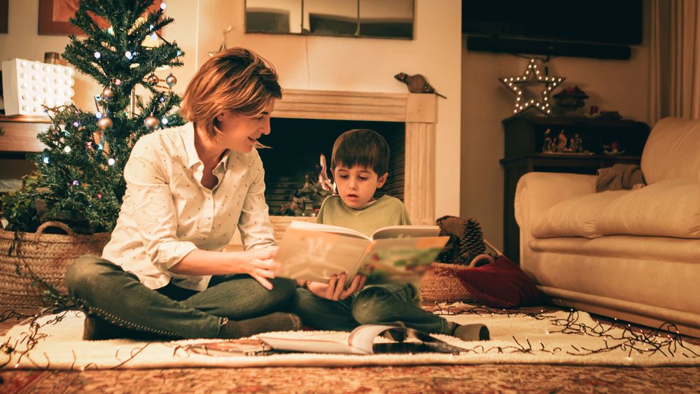 Mother reading book with son on Christmas eve