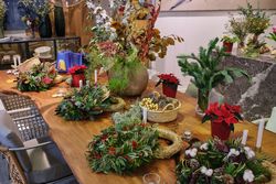 Various floral compositions and Christmas wreaths on table in fl