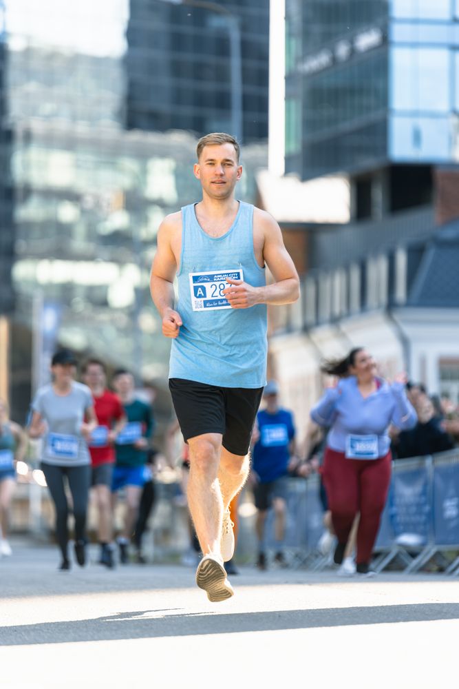 Portrait of Athletic Male Jogger and Supporters in the Audience While They Cheer for Him on a Marathon.