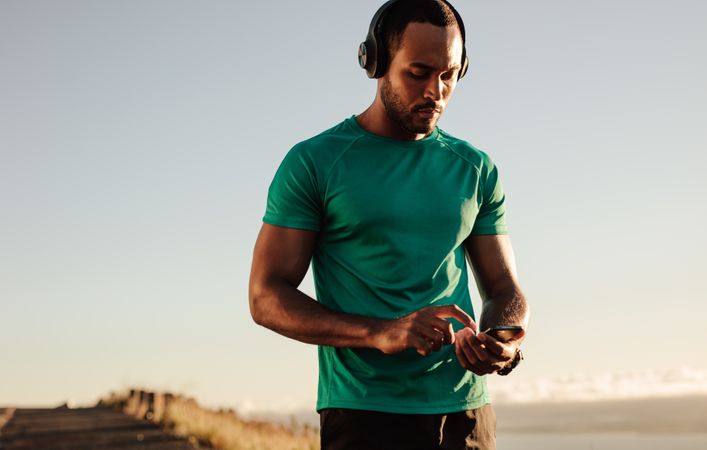 Athletic man listening to music on wireless headphones
