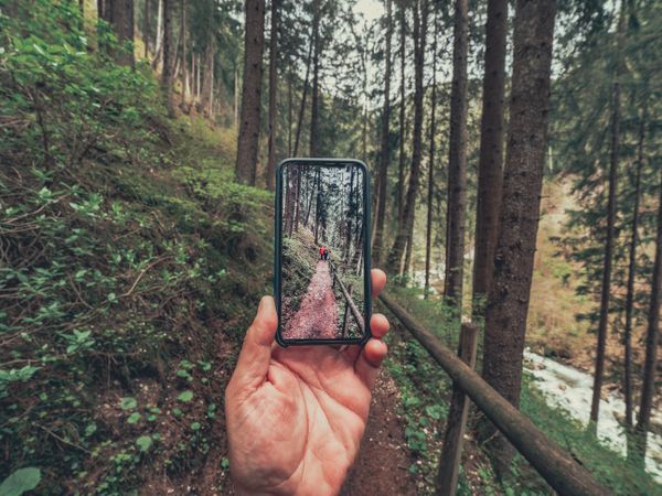 Tourist taking photo while walking on footpath