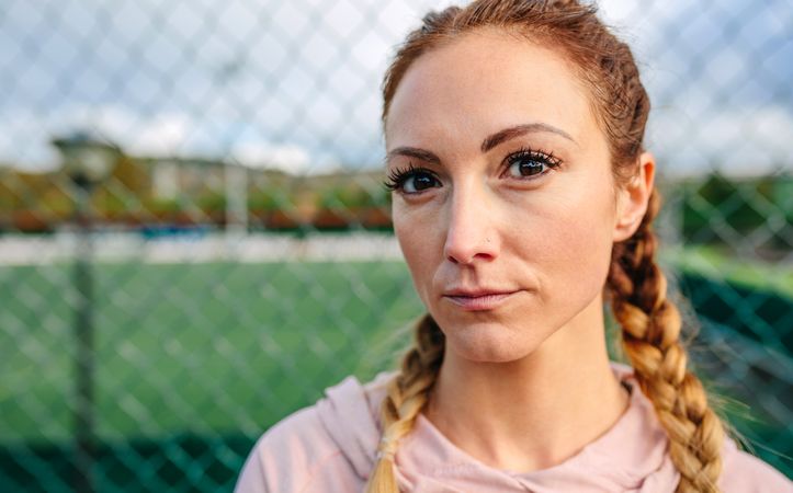 Serious young sportswoman with boxer braids looking camera