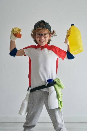 Excited superhero in red cape and cleaner costume in studio