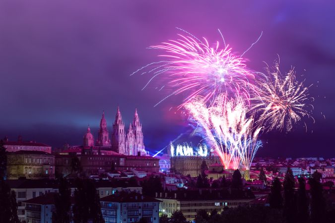 Fireworks above towers of castle in European city at night