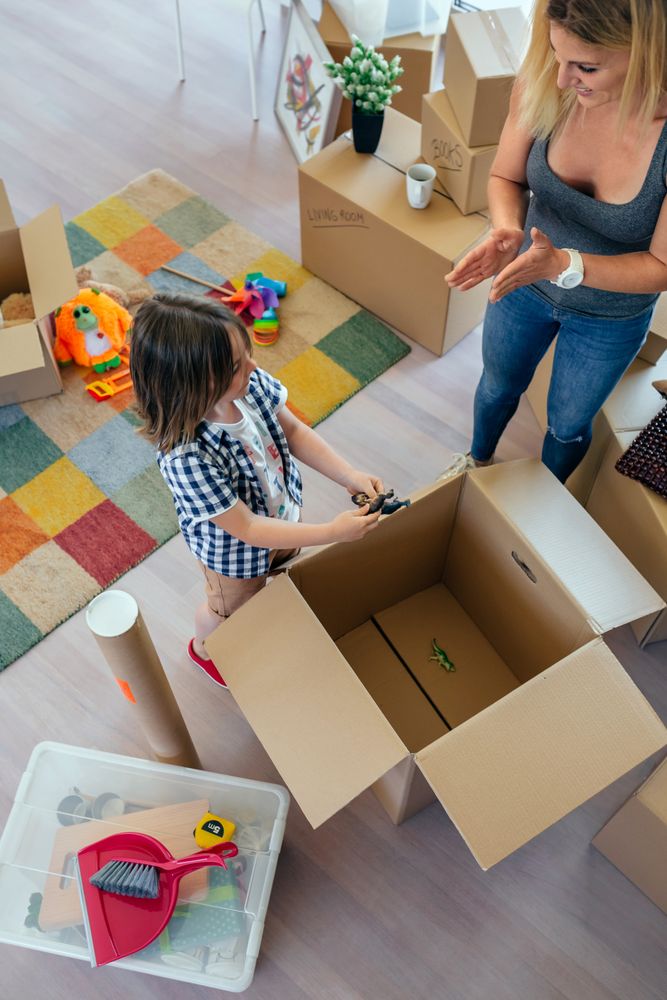Mother and son unpacking moving box